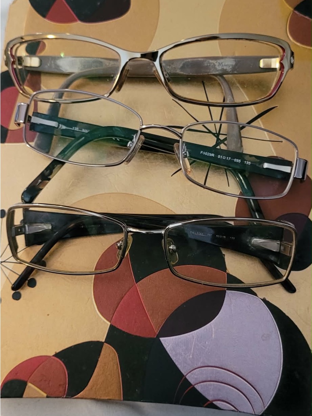 Three pair of designer glasses with prescription lenses.